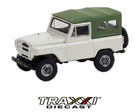 GreenLight 1:64 1973 Nissan Patrol 60 white off-road vehicle with green roof and rear-mounted spare tire front three-quarter view