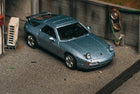 Porsche 928 GTS Blue Metallic by Tarmac Works in 1:64 scale, featuring raised pop-up headlights, rolling wheels and Global64 collaboration with IXO Models.